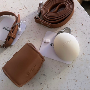 the brown poop bag holder with collar leash and treat pouch