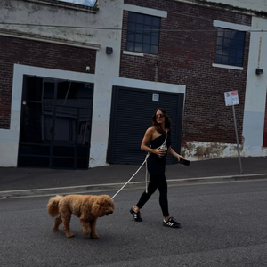 the cream cross body leash worn around the shoulder