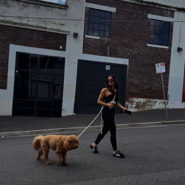 the cream cross body leash worn around the shoulder