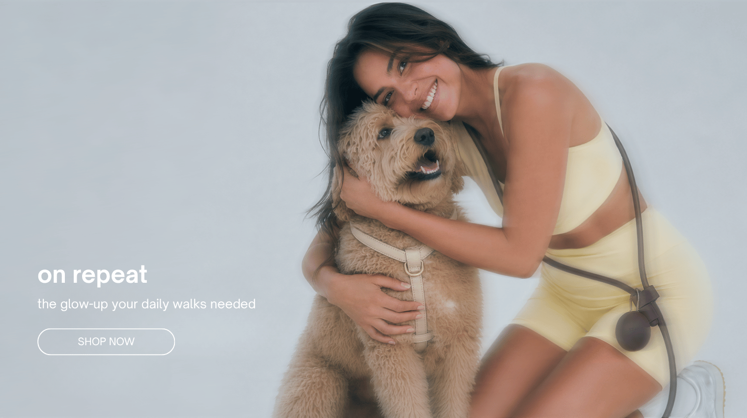 Dog wearing a cream harness with a woman wearing a hands free dog leash