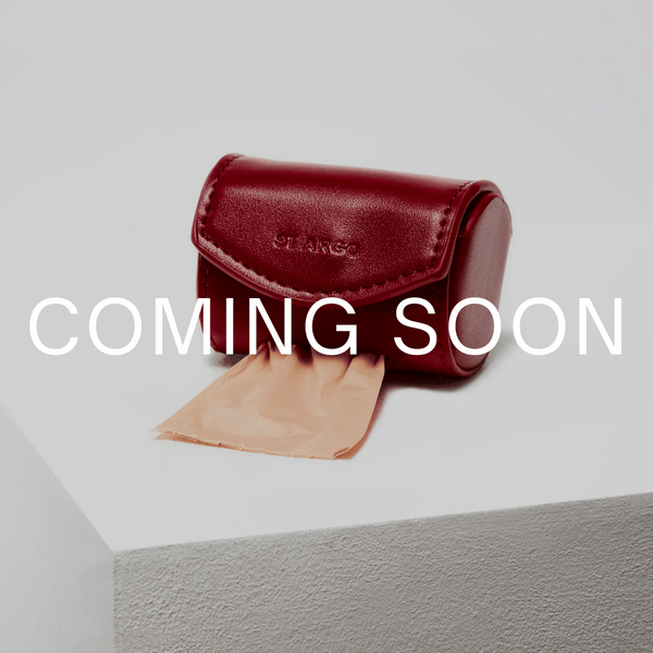 Red leather case with a beige fabric on a gray surface, labeled 'Coming Soon'.
